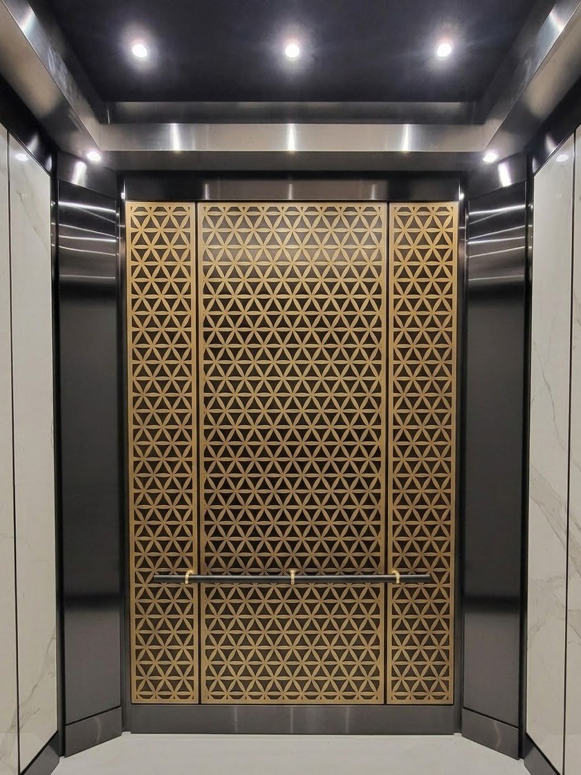 Elevator cab with decorative metal panels